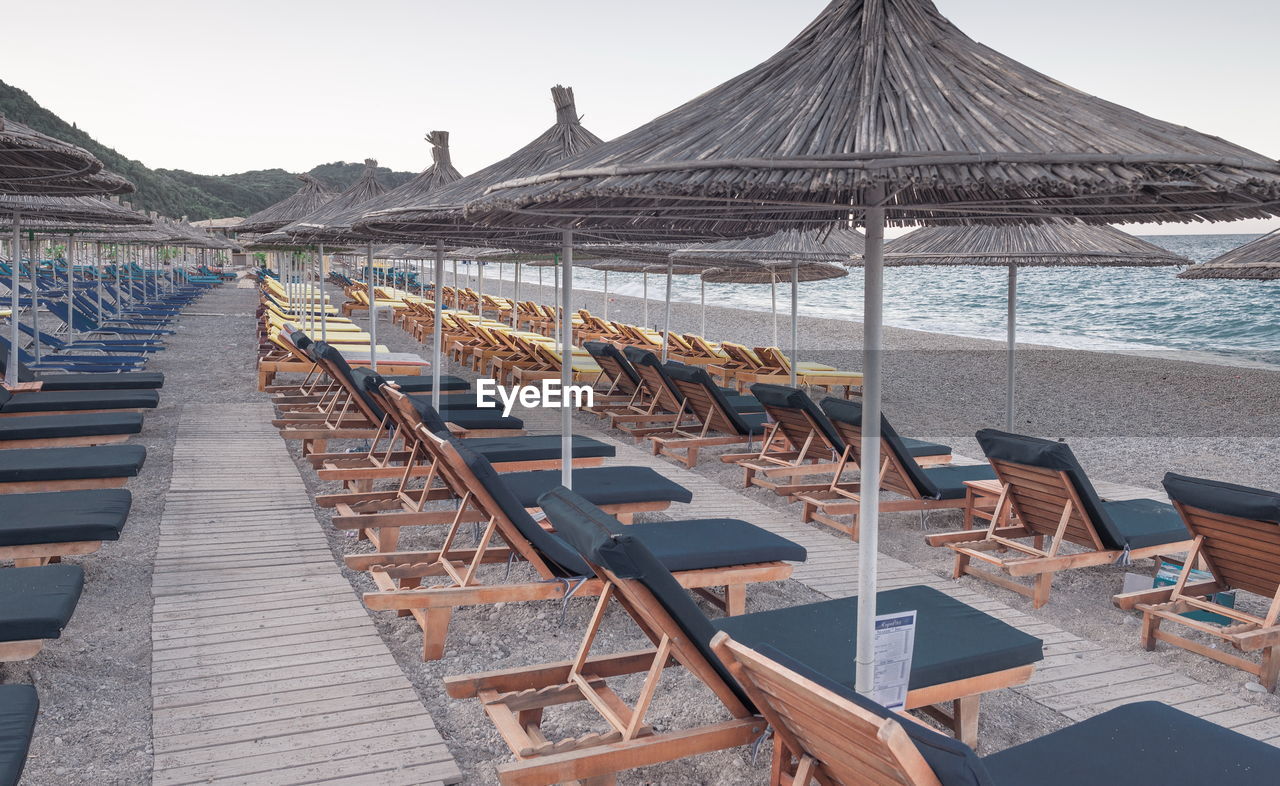 PANORAMIC VIEW OF LOUNGE CHAIRS ON BEACH