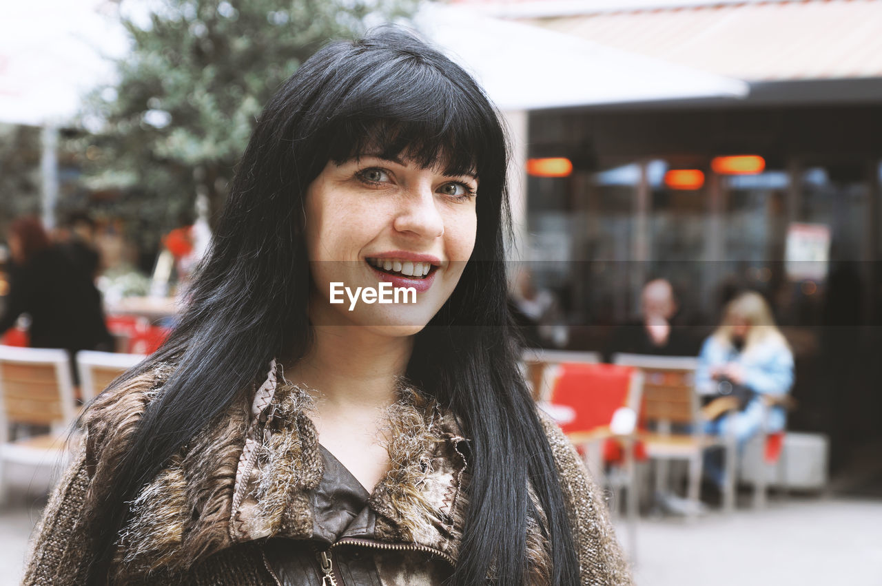 Portrait of smiling woman in city