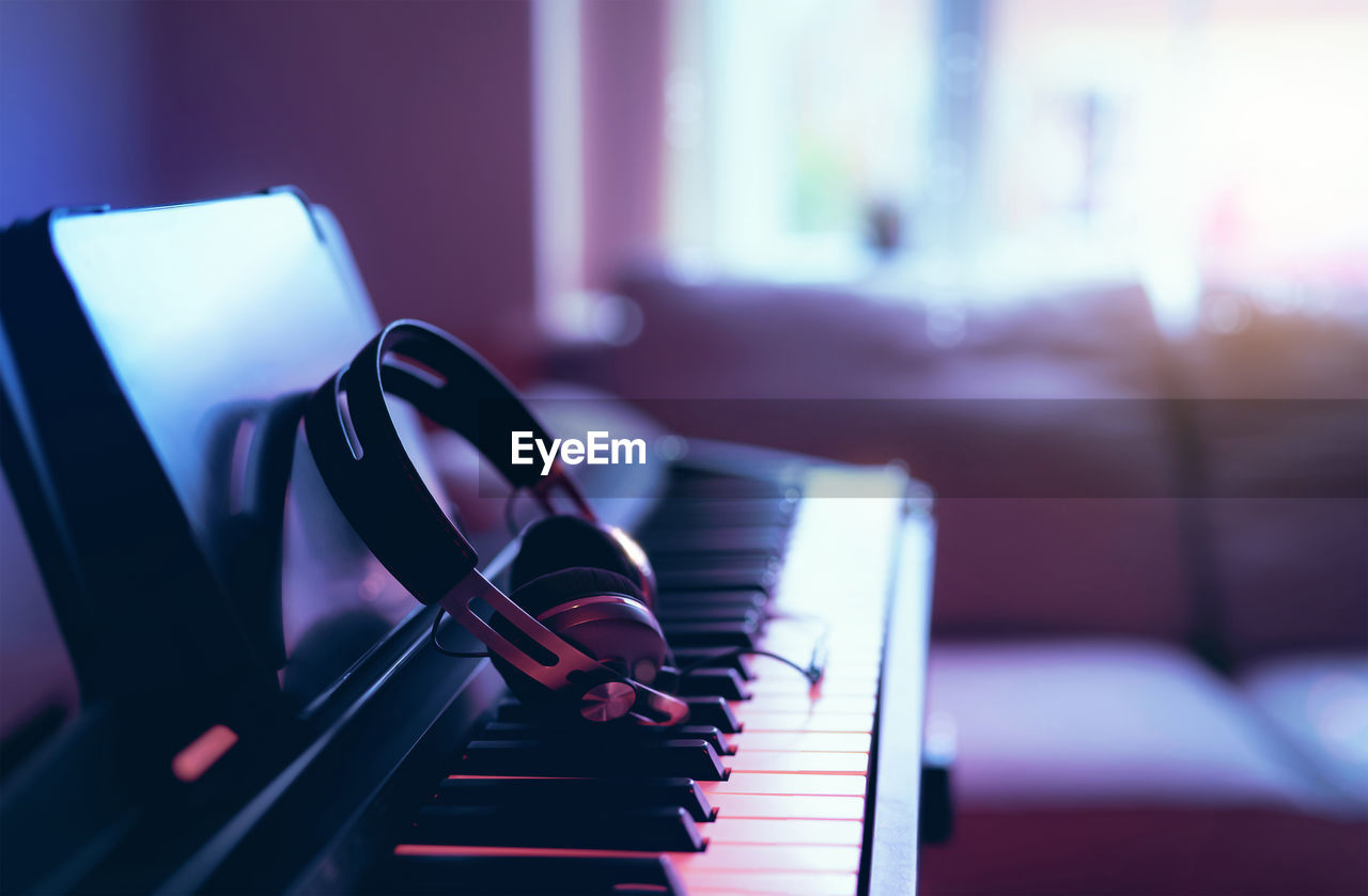 Close-up of piano with headphones at home