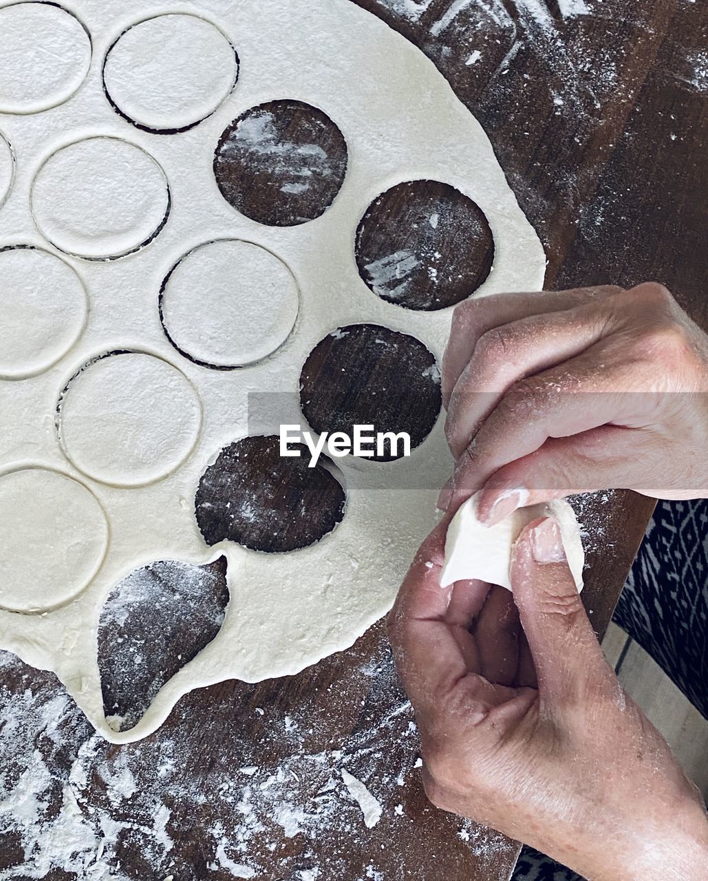 HIGH ANGLE VIEW OF WOMAN PREPARING FOOD AT TABLE