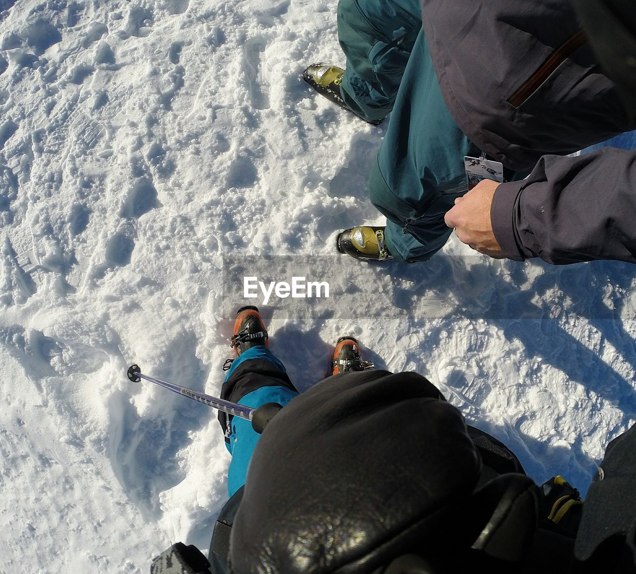 Low section of people standing on snow