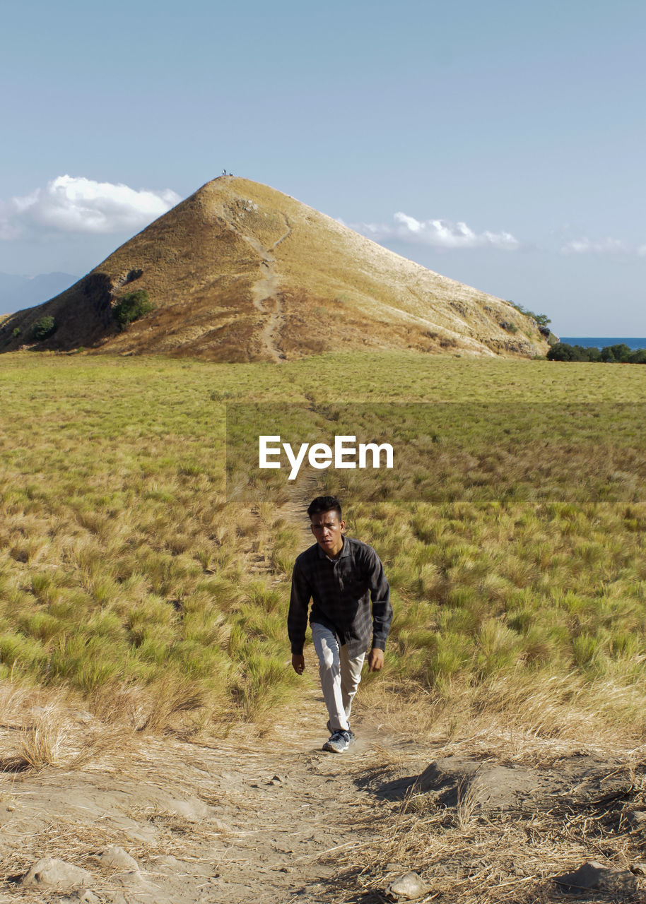 Full length of man standing on field against sky