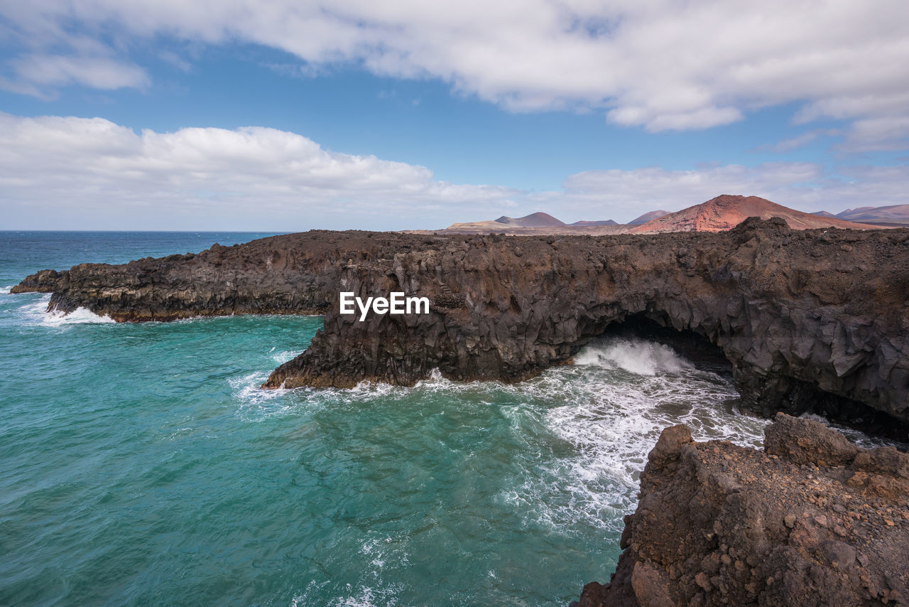 Rock formation in sea against sky