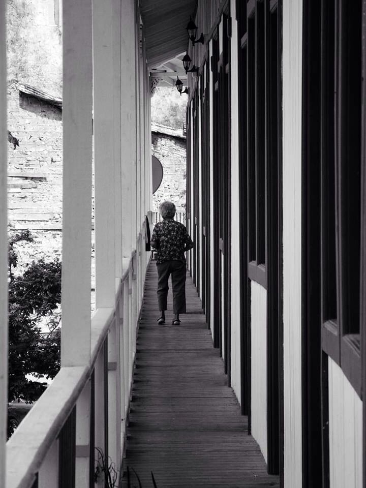 FULL LENGTH REAR VIEW OF WOMAN WALKING ON FOOTBRIDGE