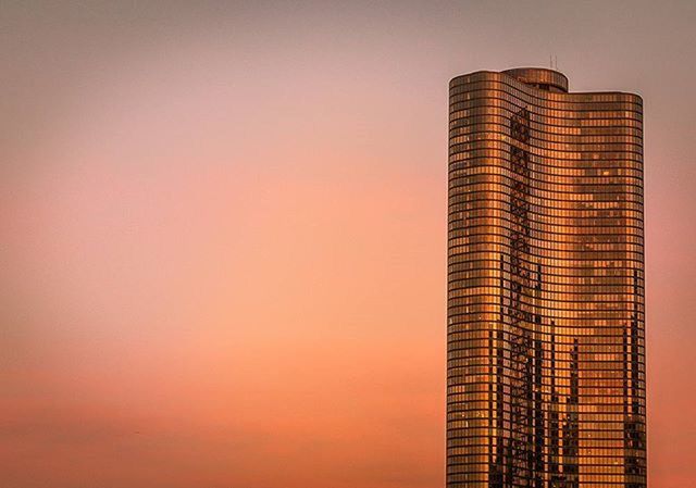 LOW ANGLE VIEW OF SKYSCRAPER AT SUNSET