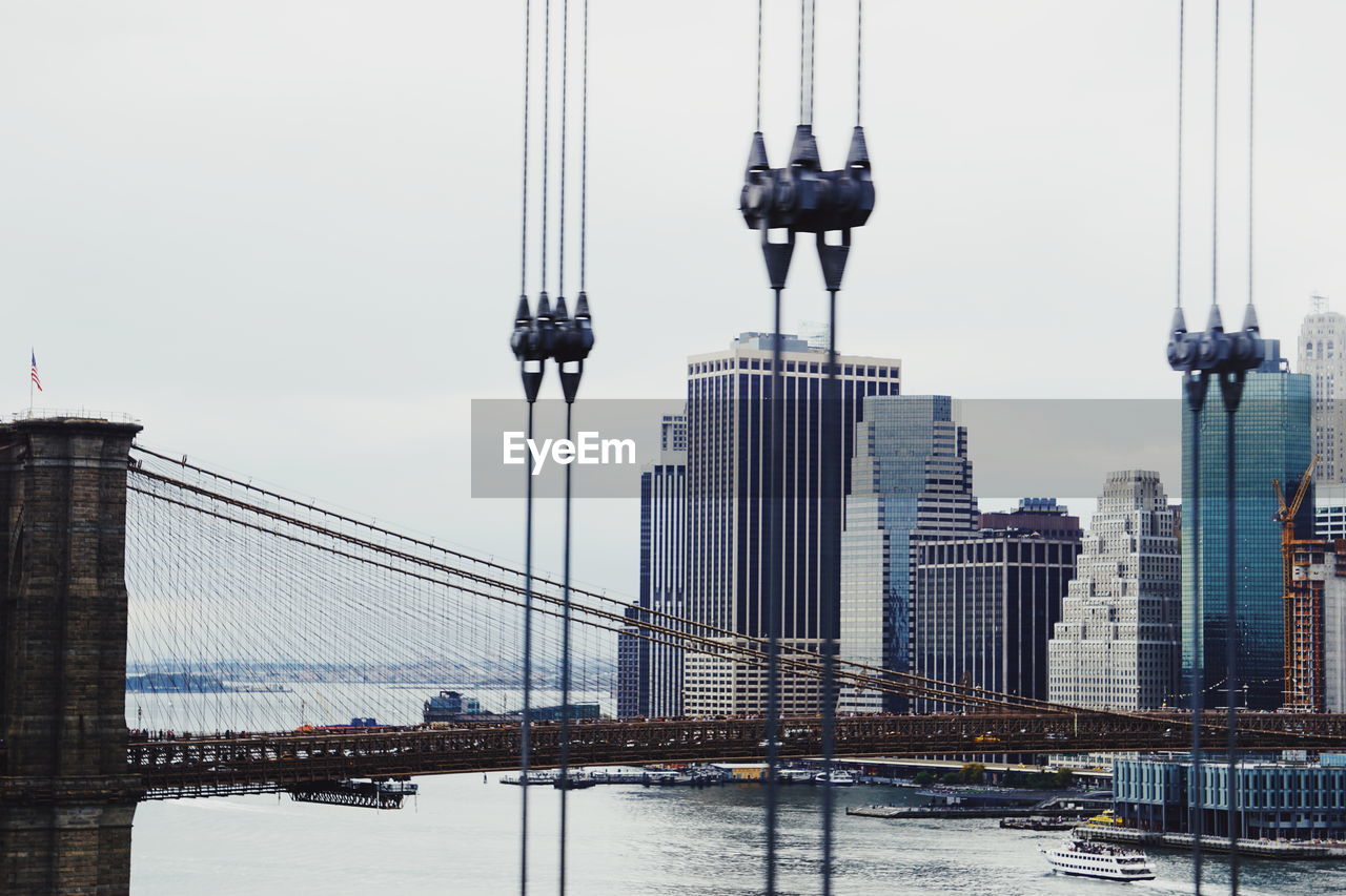 Bridge in city against clear sky