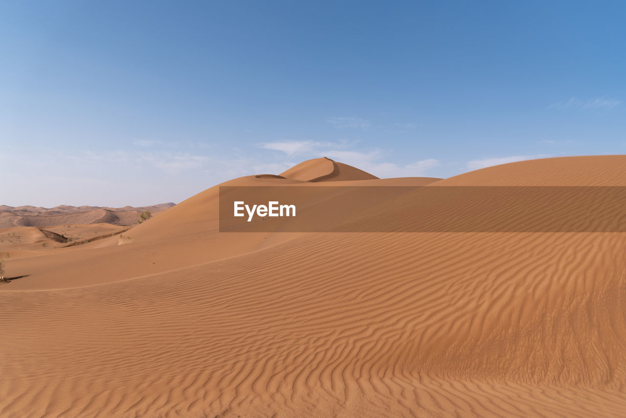 SCENIC VIEW OF SAND DUNES IN DESERT AGAINST SKY