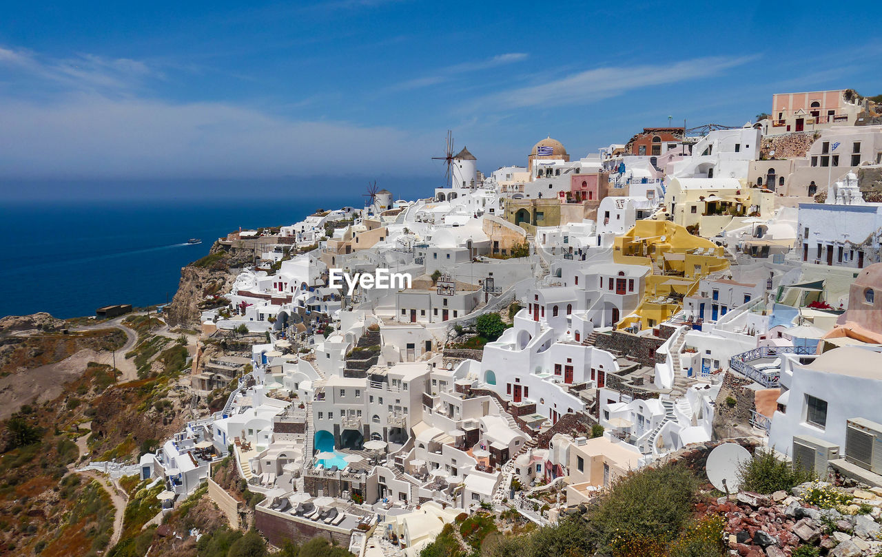 High angle view of townscape by sea against sky