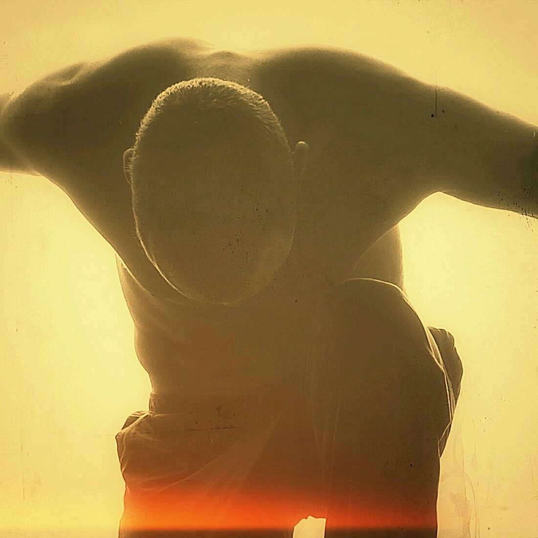 Close-up of shirtless man exercising against sky