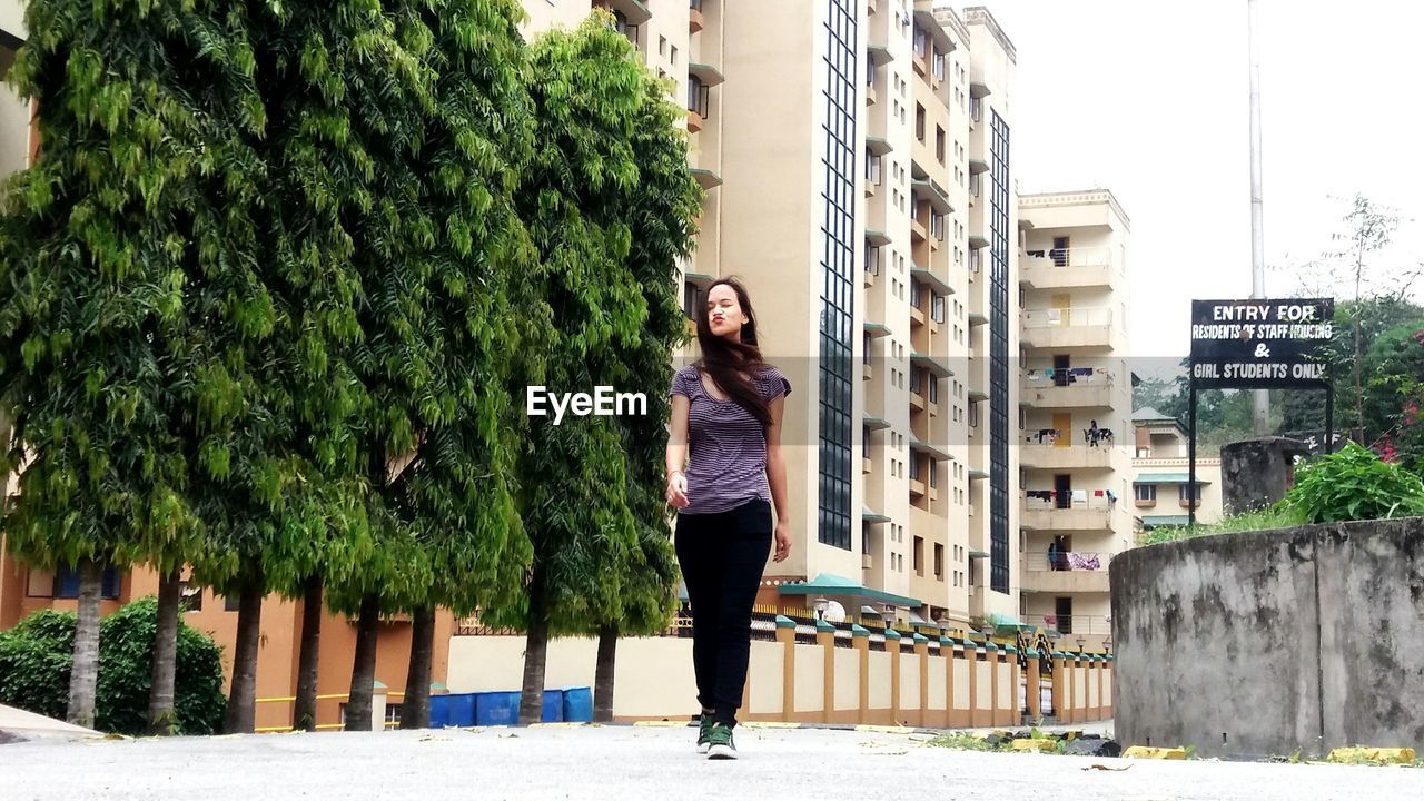 WOMAN WALKING ON CITY STREET