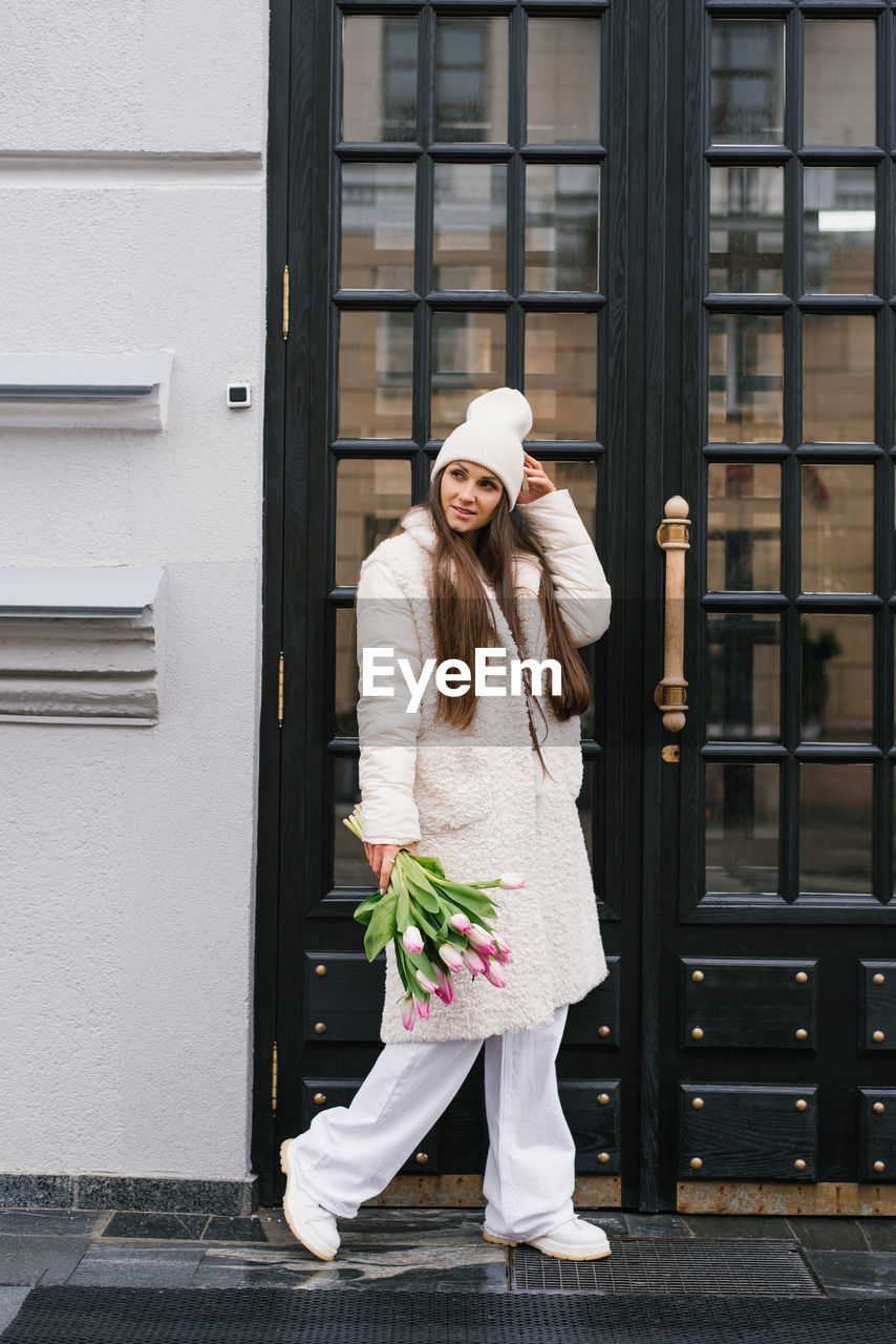 Young woman with tulips on city street