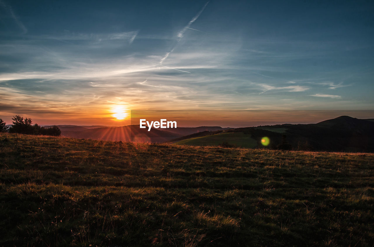 Scenic view of field against sky during sunset