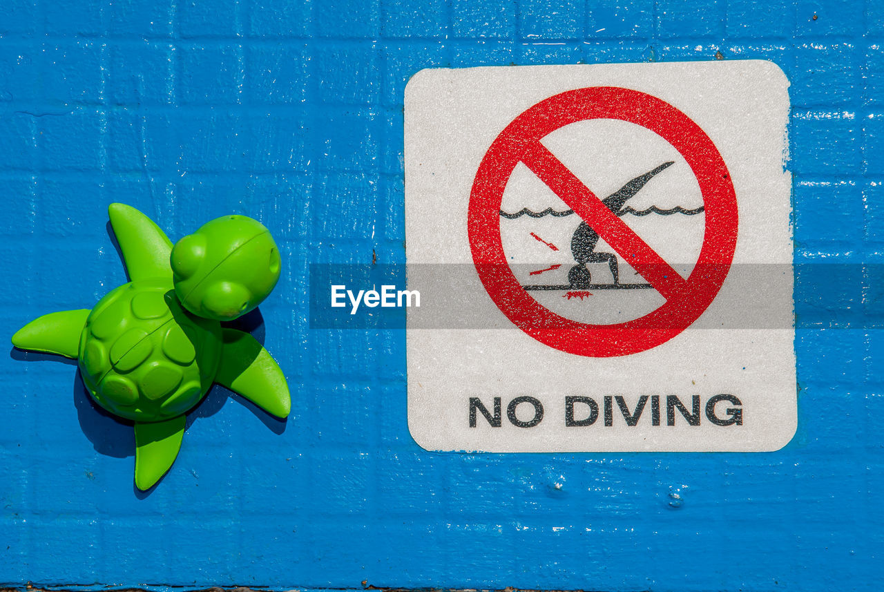 CLOSE-UP OF SIGN ON BLUE WALL