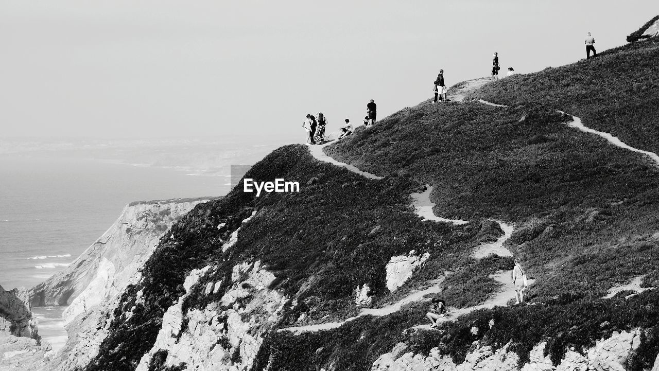 Scenic view of cliff by sea against sky