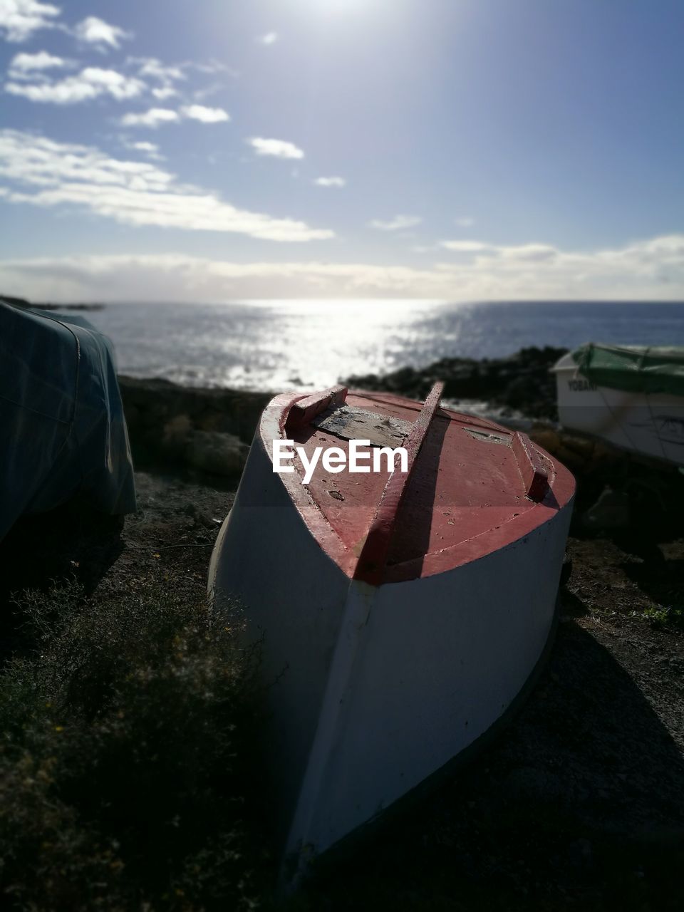 CLOSE-UP OF BOAT ON BEACH AGAINST SKY DURING SUNSET