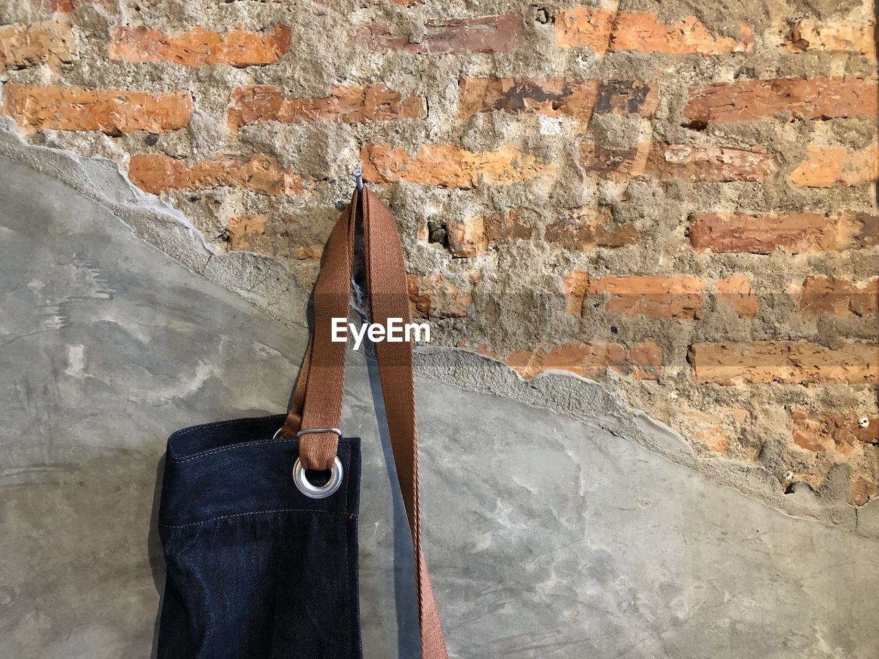 Close-up of apron clothes hanging on old brick wall