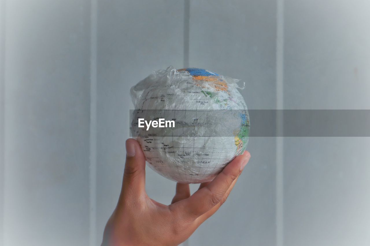 Cropped hand of person holding globe