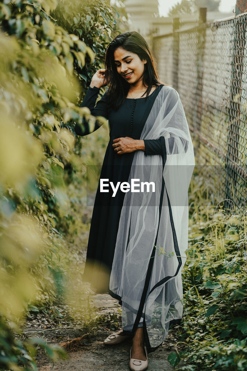 portrait of young woman standing in forest