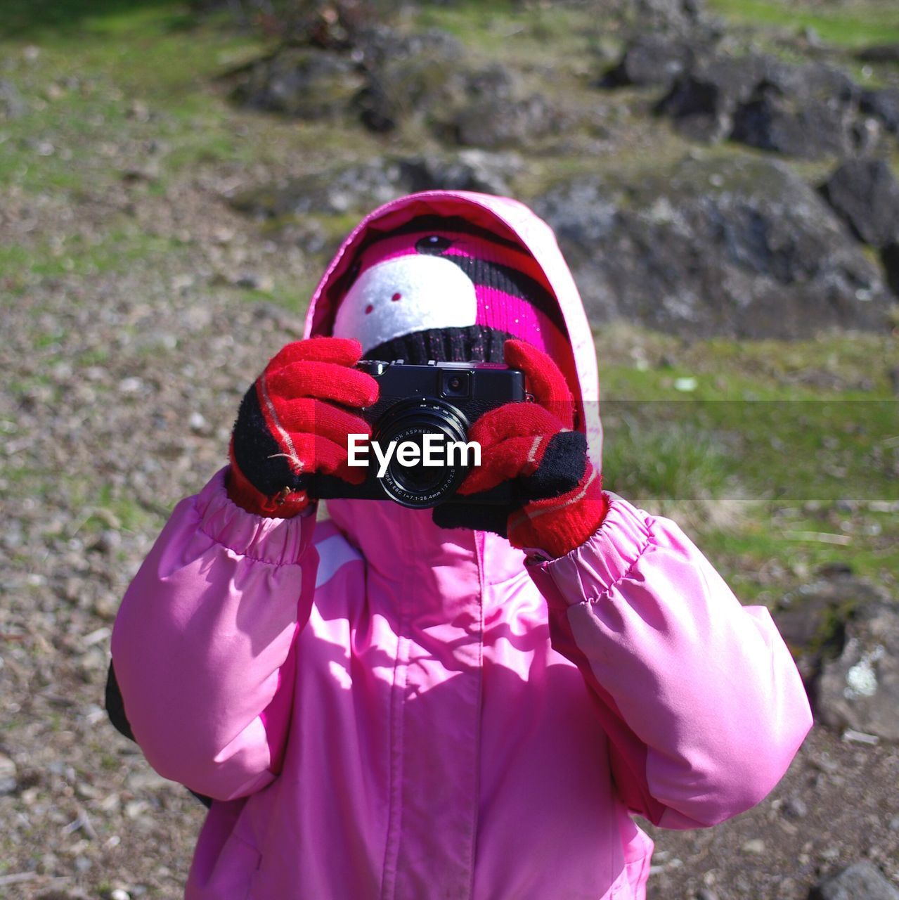 Close-up of woman photographing with camera on field