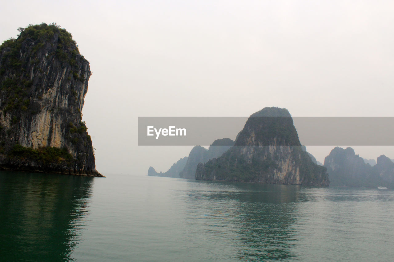 Rock formations on halong bay against clear sky