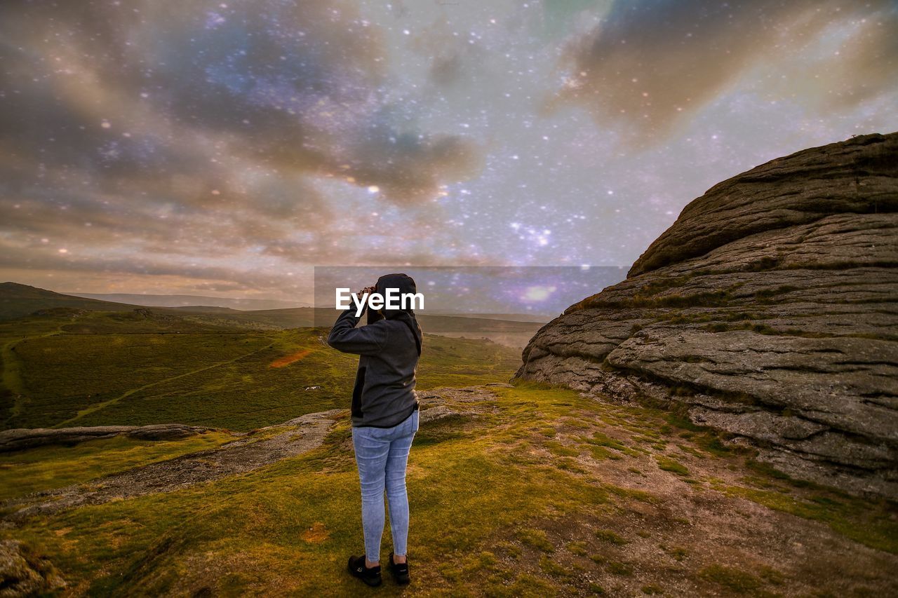 Rear view of man standing on land against sky