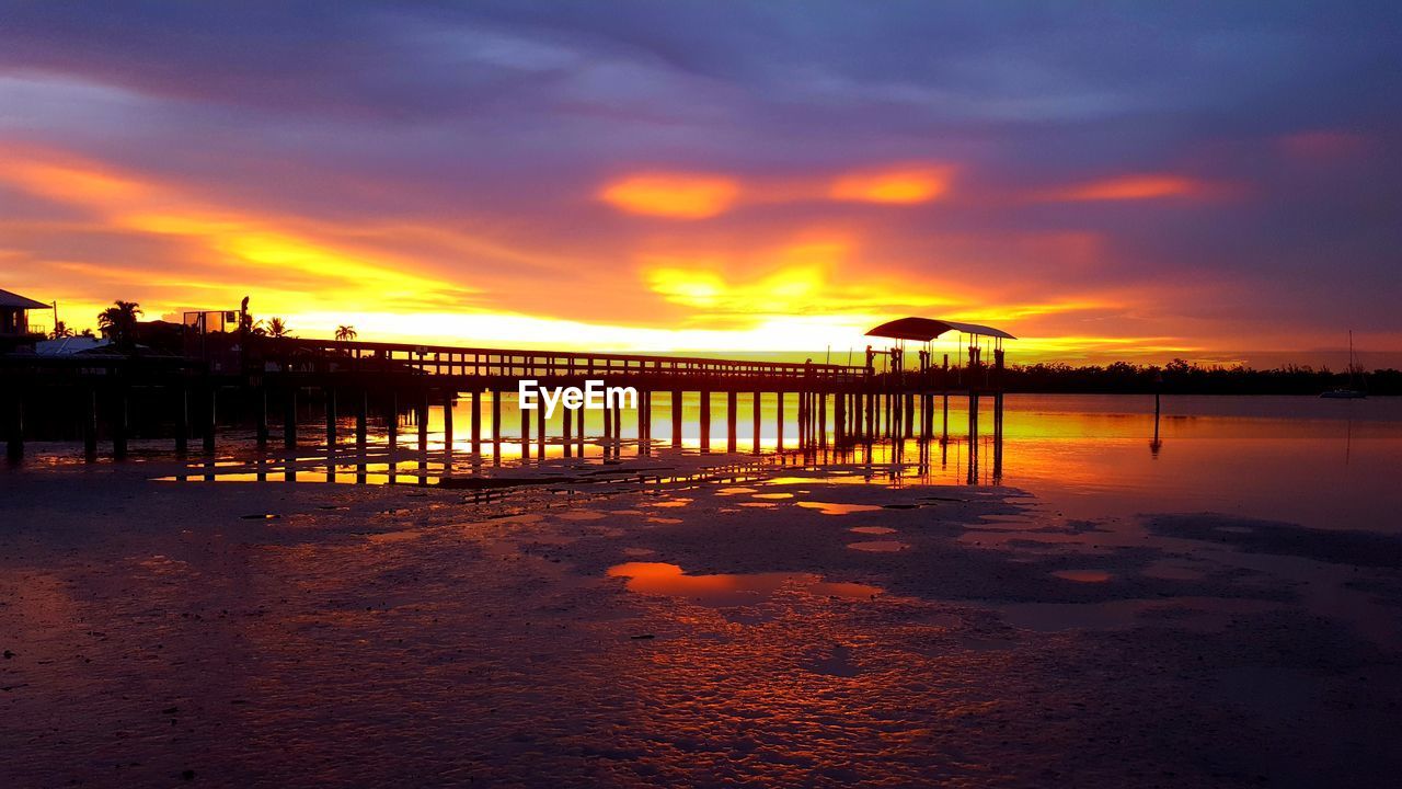 PIER OVER SEA AGAINST ORANGE SKY