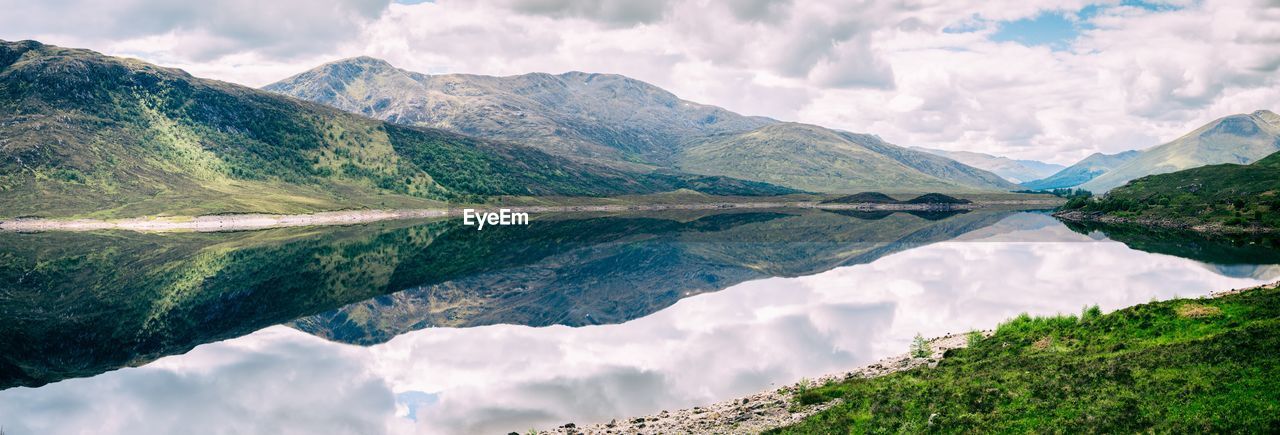 Lake in scotland with very still water reflecting the scenic mountains of the landscape