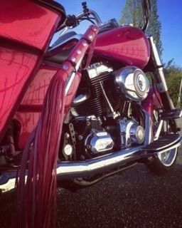 CLOSE-UP OF PINK MOTORCYCLE AGAINST SKY