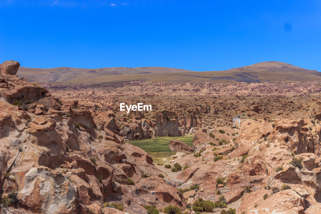 Scenic view of rocky mountains against clear blue sky