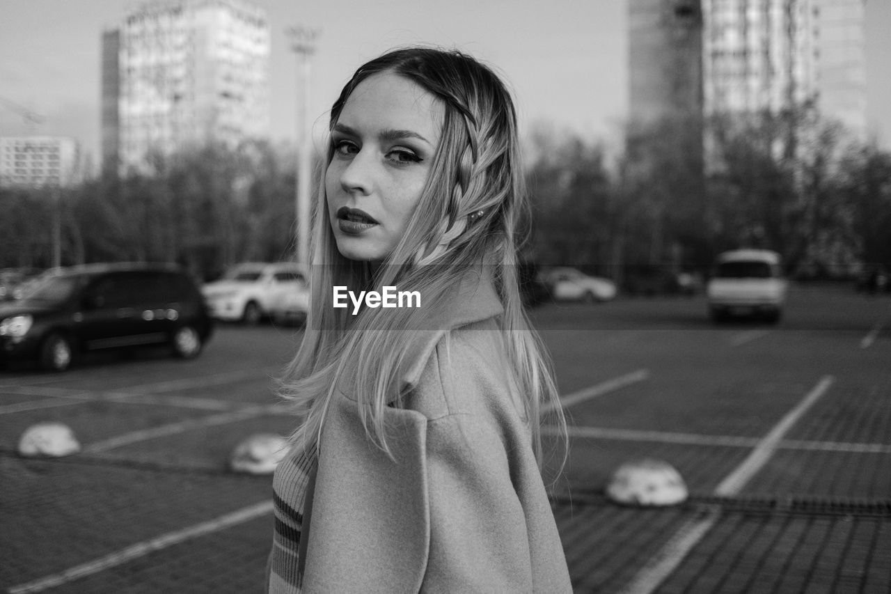 Portrait of beautiful woman standing in city black and white 