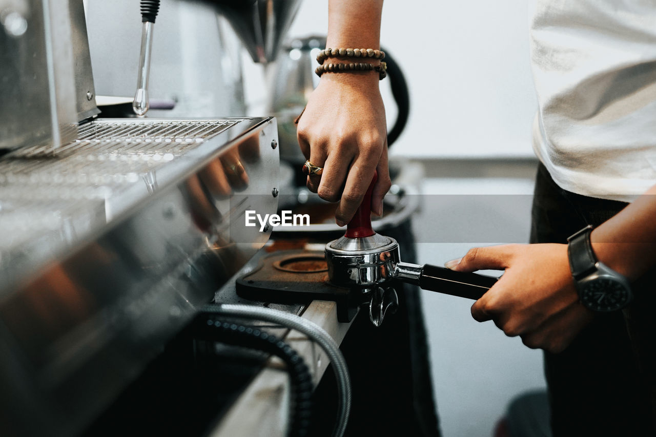 Midsection of man holding preparing coffee