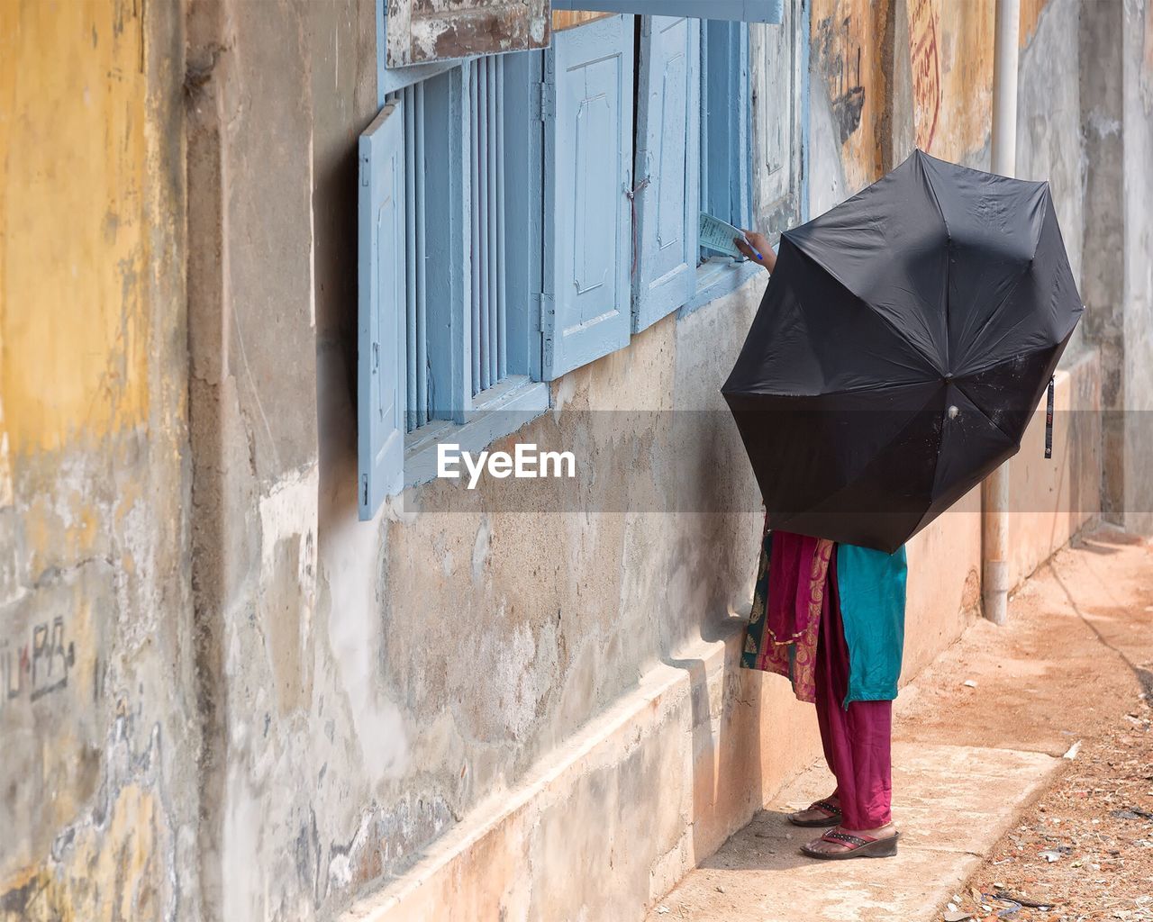 Woman holding umbrella outside building