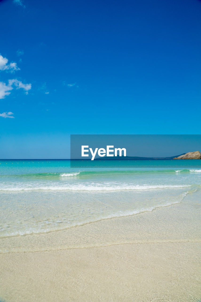 Scenic view of beach against blue sky