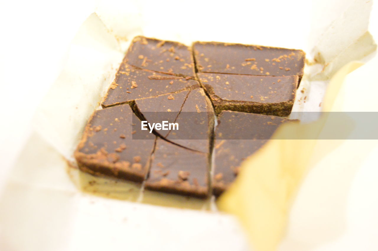 Close-up of chocolate in wrapping paper on white background