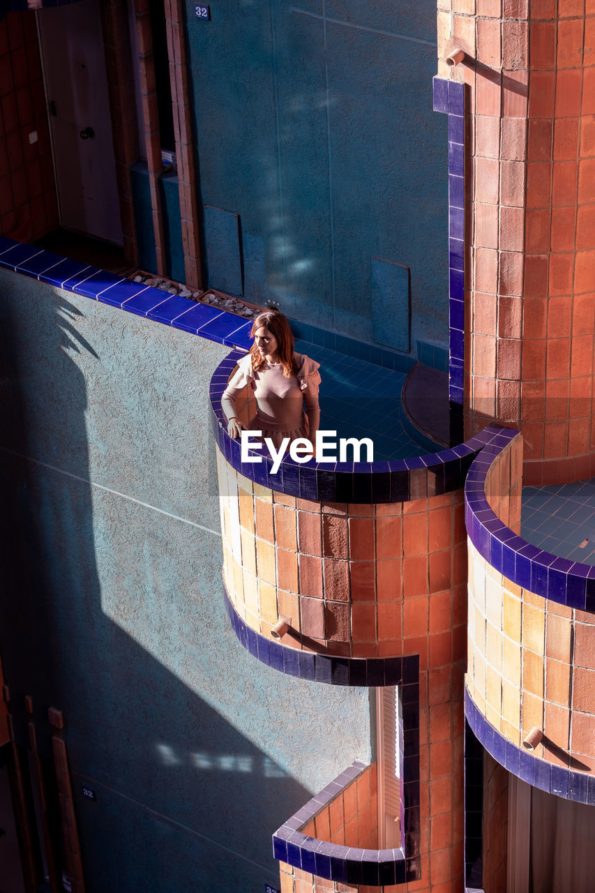 High angle view of woman standing on balcony