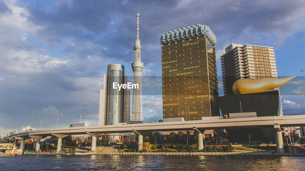 Low angle view of tokyo sky tree by sumida river against sky