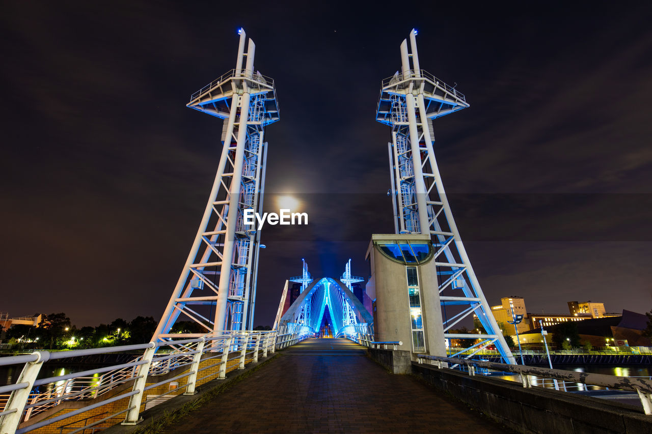 Illuminated tower bridge against sky at night