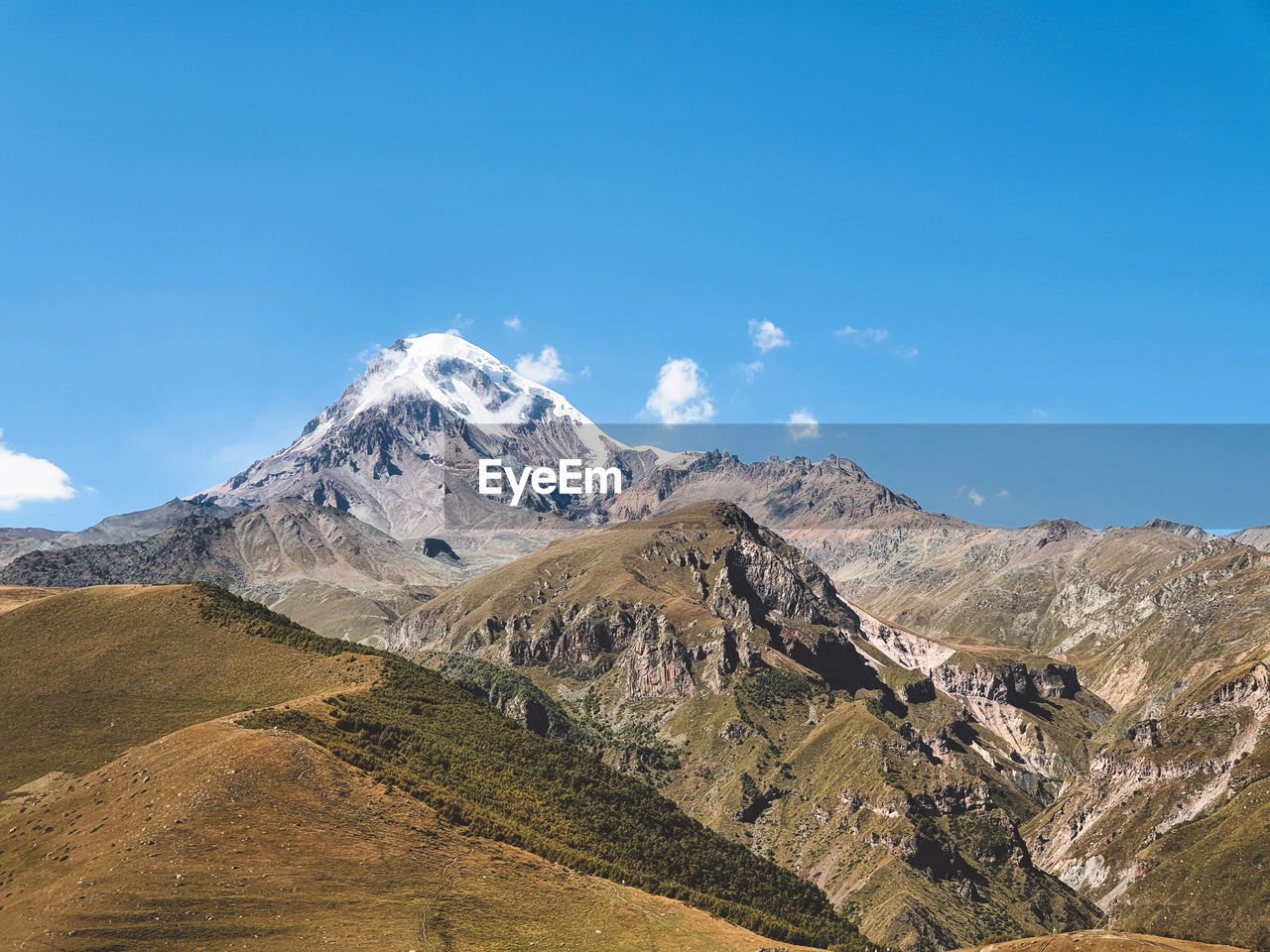 Scenic view of snowcapped mountains against clear blue sky.