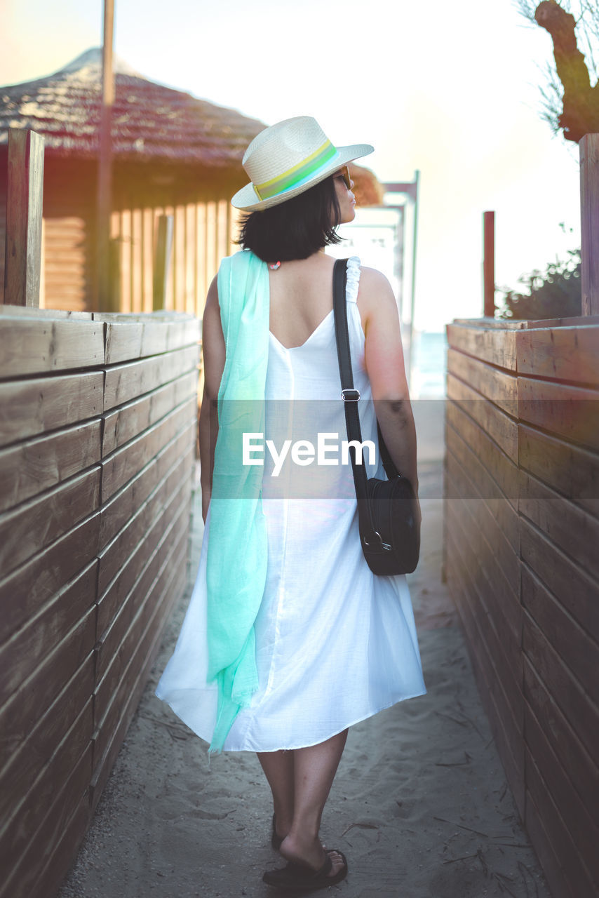 Rear view of woman walking amidst retaining wall