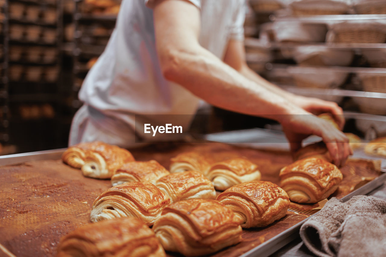 Midsection of baker preparing pastry 