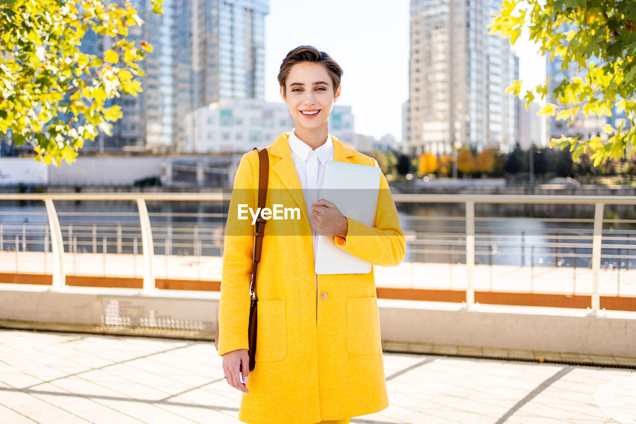 portrait of young man standing against building