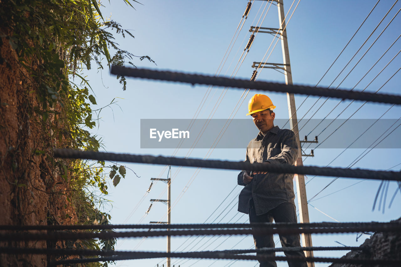 MAN WORKING ON ELECTRICITY PYLON