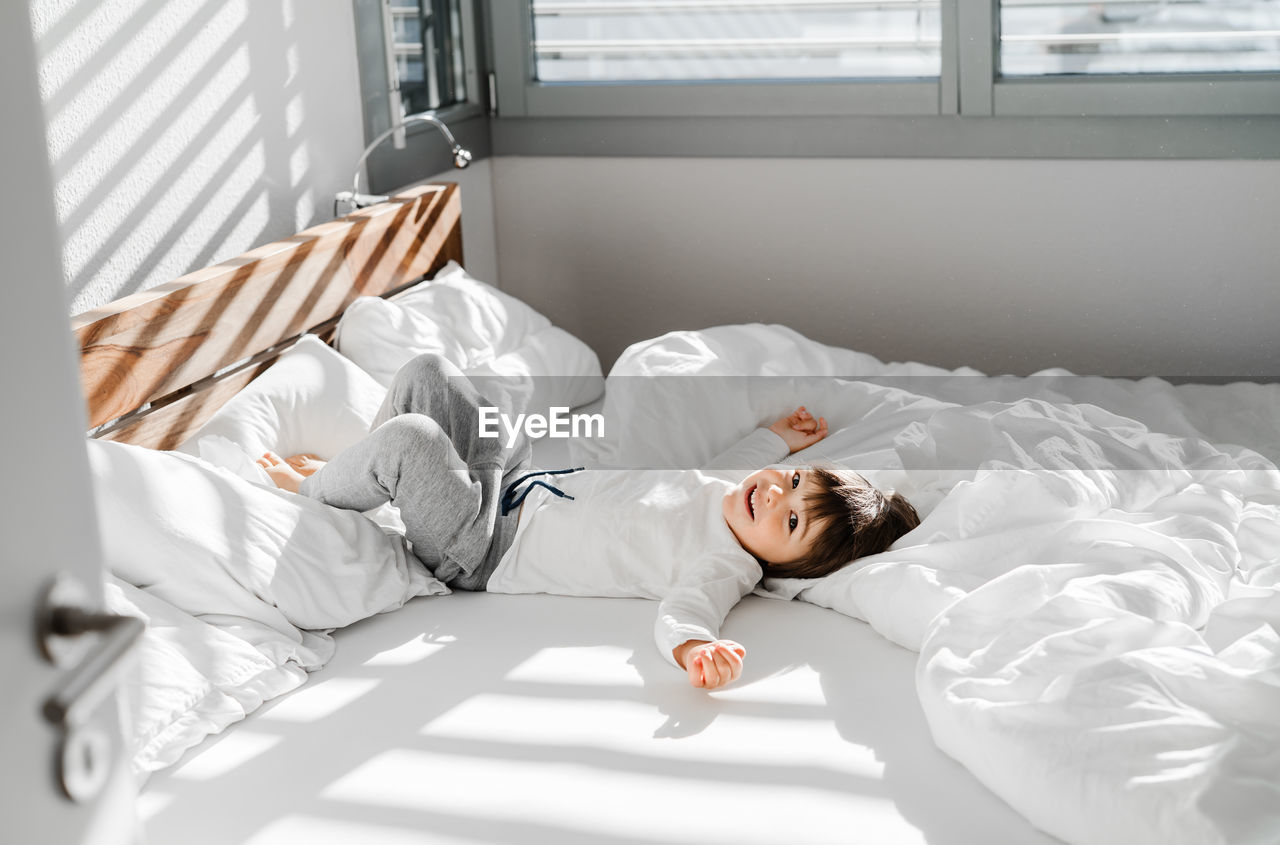 High angle view of boy lying down on floor at home