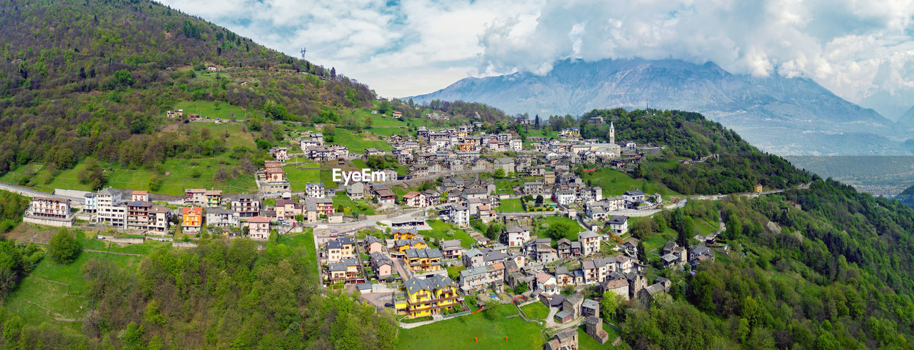 PANORAMIC SHOT OF TOWNSCAPE AND MOUNTAINS AGAINST SKY