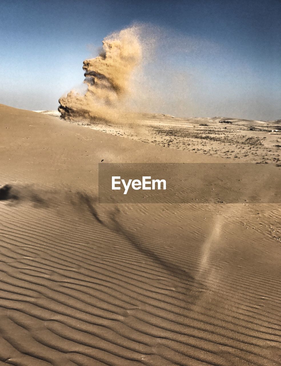 Sand dunes in desert against clear sky