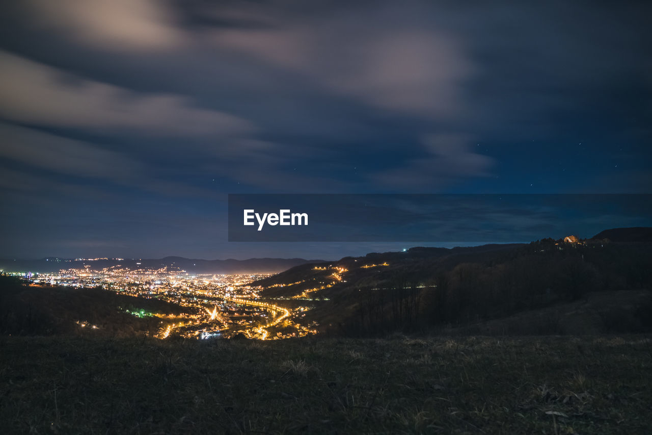 Illuminated cityscape against sky at night