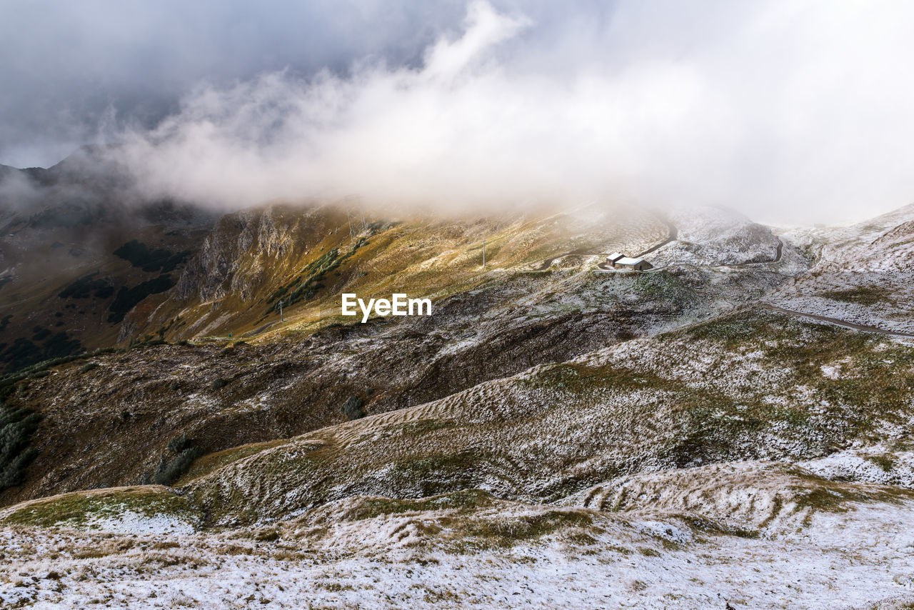 Scenic view of mountains against cloudy sky