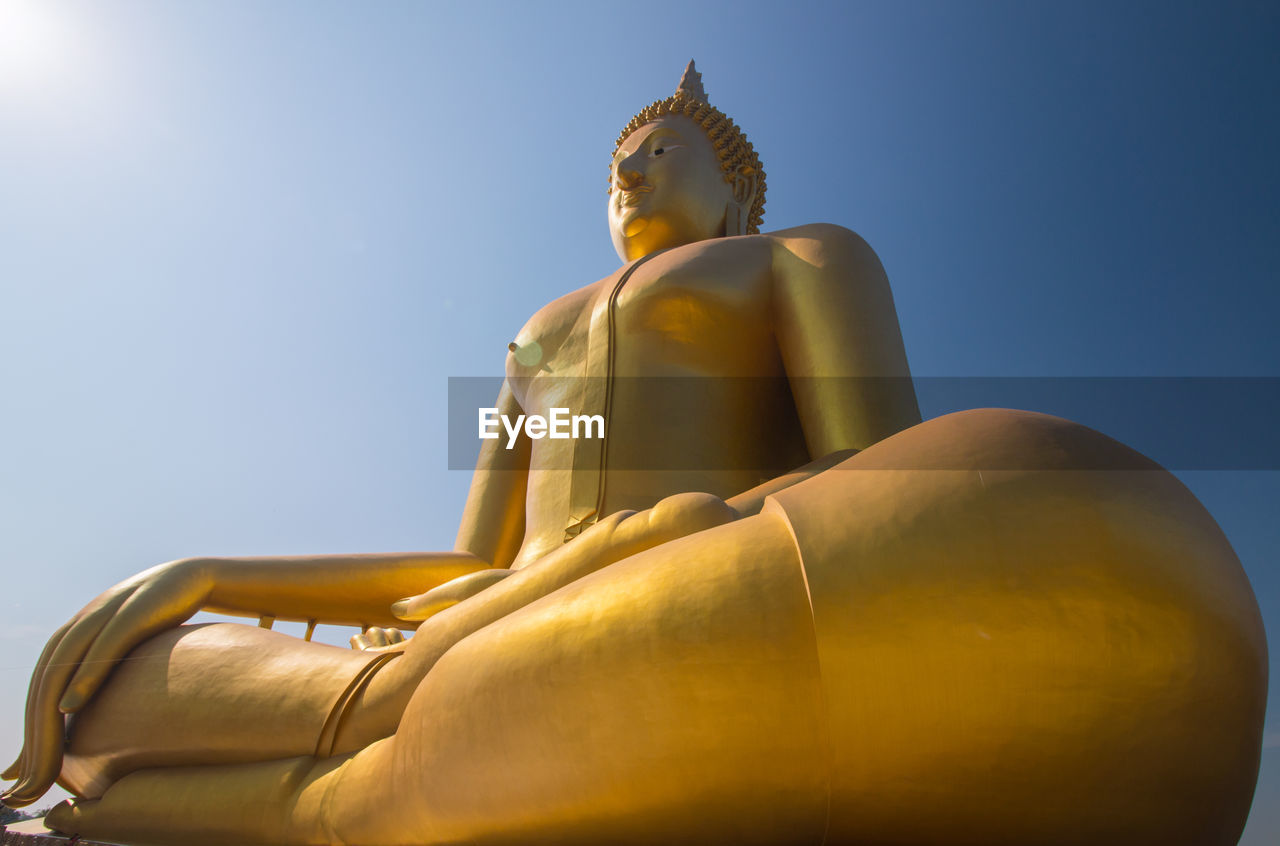 Close-up of buddha statue against sky