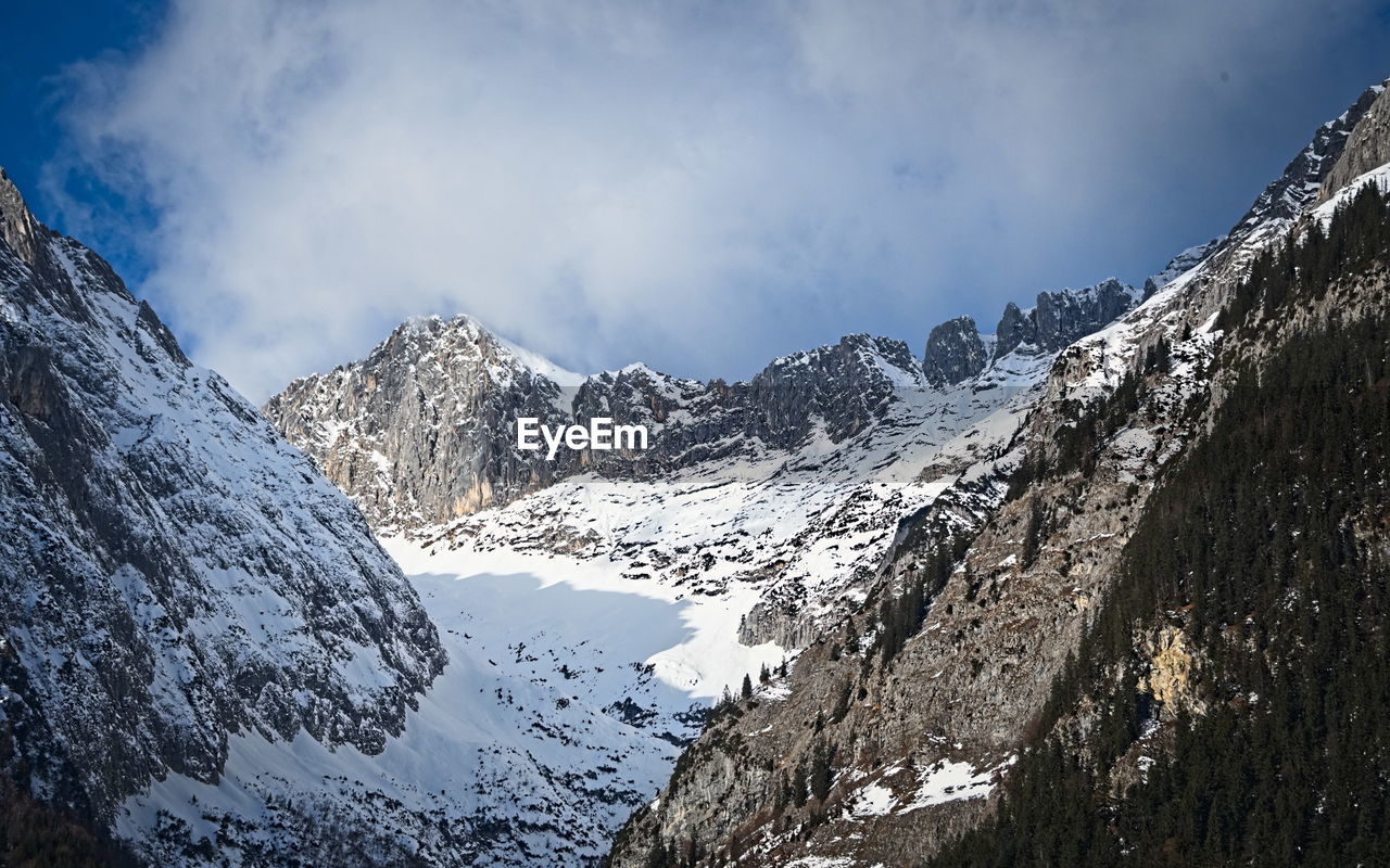 snow, mountain, cold temperature, winter, scenics - nature, sky, environment, mountain range, beauty in nature, nature, landscape, snowcapped mountain, cloud, ridge, travel destinations, travel, no people, panoramic, mountain pass, land, mountain peak, pinaceae, outdoors, coniferous tree, pine tree, forest, tourism, adventure, non-urban scene, sports, ice, tranquility, summit, tranquil scene, activity, day, tree, blue, extreme terrain, wilderness, leisure activity, rock, plant, winter sports, pine woodland