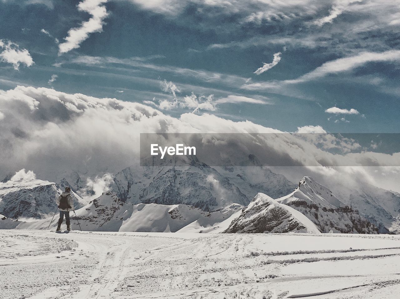 Rear view of skier walking towards mountains